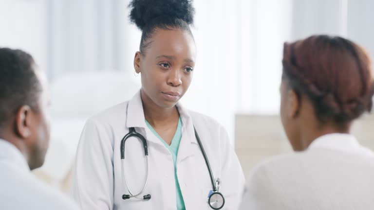 Sad black doctor, couple and consulting for pregnancy, infertility or family planning in consultation office. Doctor, gynecologist and black couple in hospital for family planning, sex or healthcare
